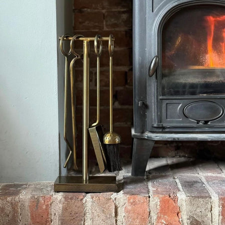 Antique Brass Fireside Tools Next to Log Burner 