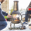 Man Burning Wood on Chimnea Fire Pit